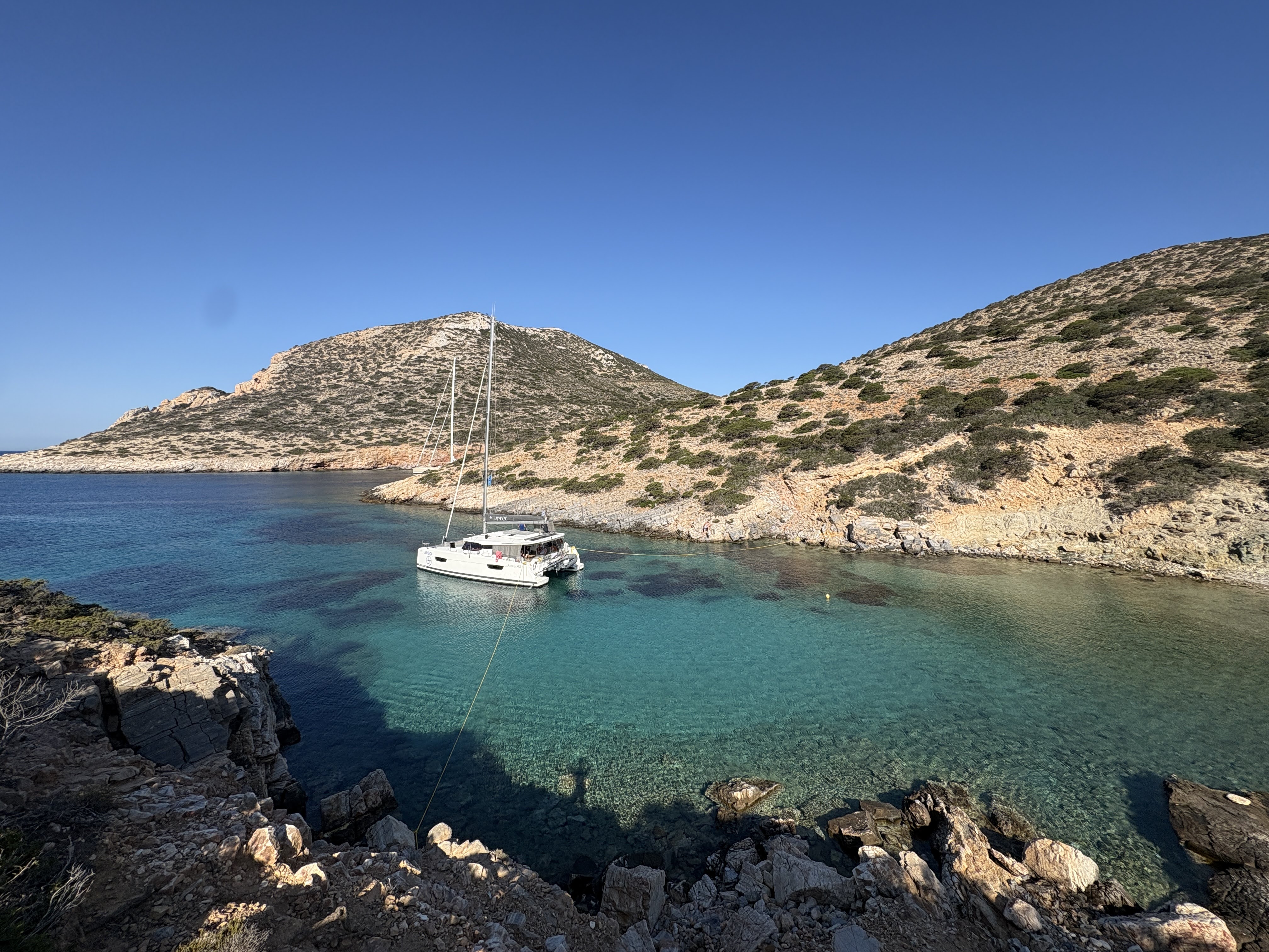 A sailing catamaran in a Greek island cover